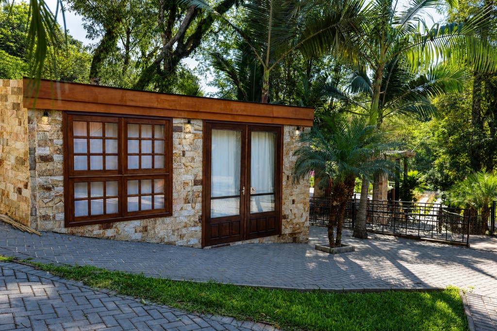 Fachada da Chácara do Cris — entrada em pedra e madeira