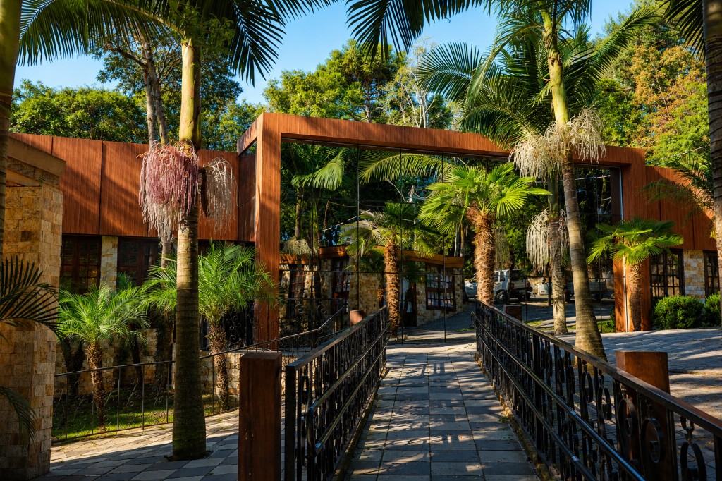 Fachada da Chácara do Cris — fachada com vidro e jardim ao redor