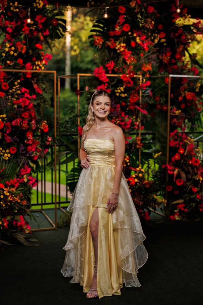 Formatura na Chácara do Cris — formanda em frente à decoração floral