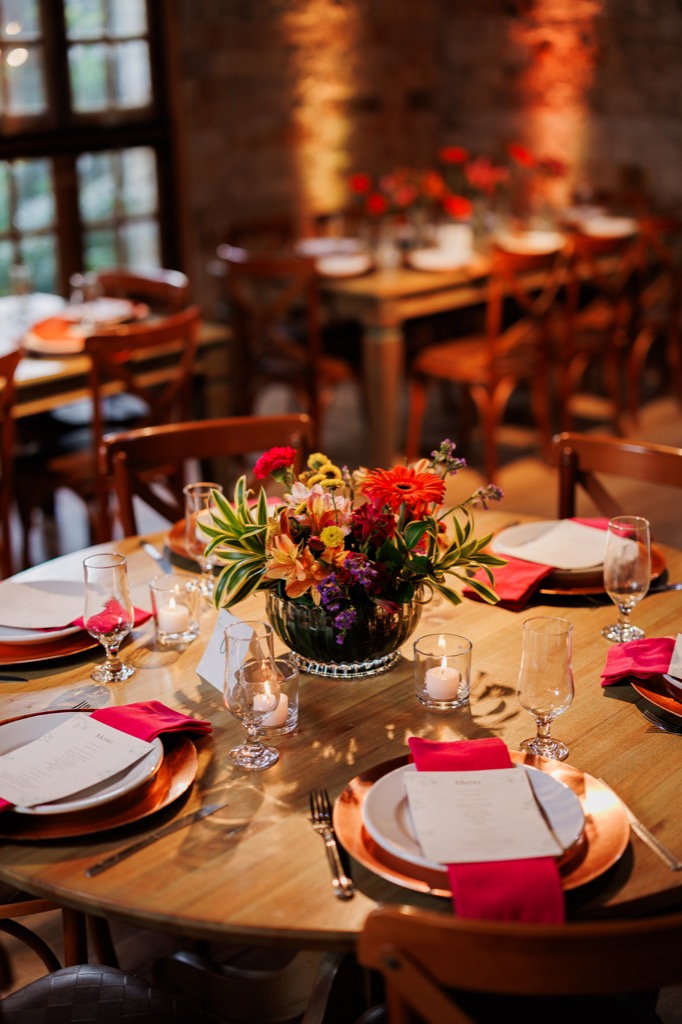 Salão de eventos na Chácara do Cris — mesa decorada com arranjo floral no teto