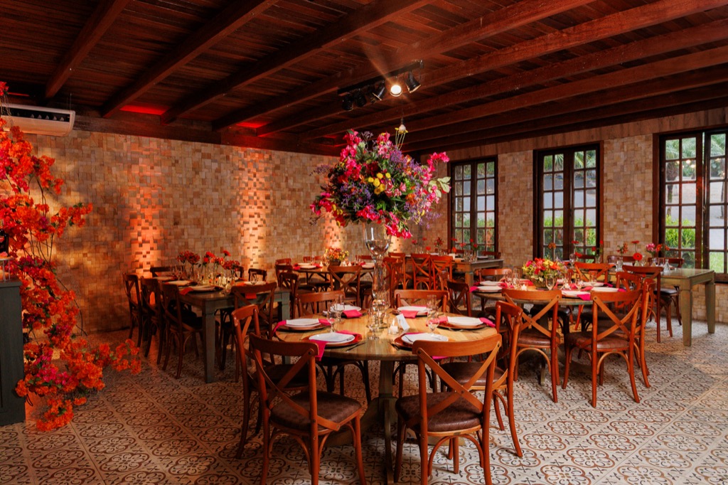 Salão de eventos na Chácara do Cris — mesa longa com instalação floral suspensa