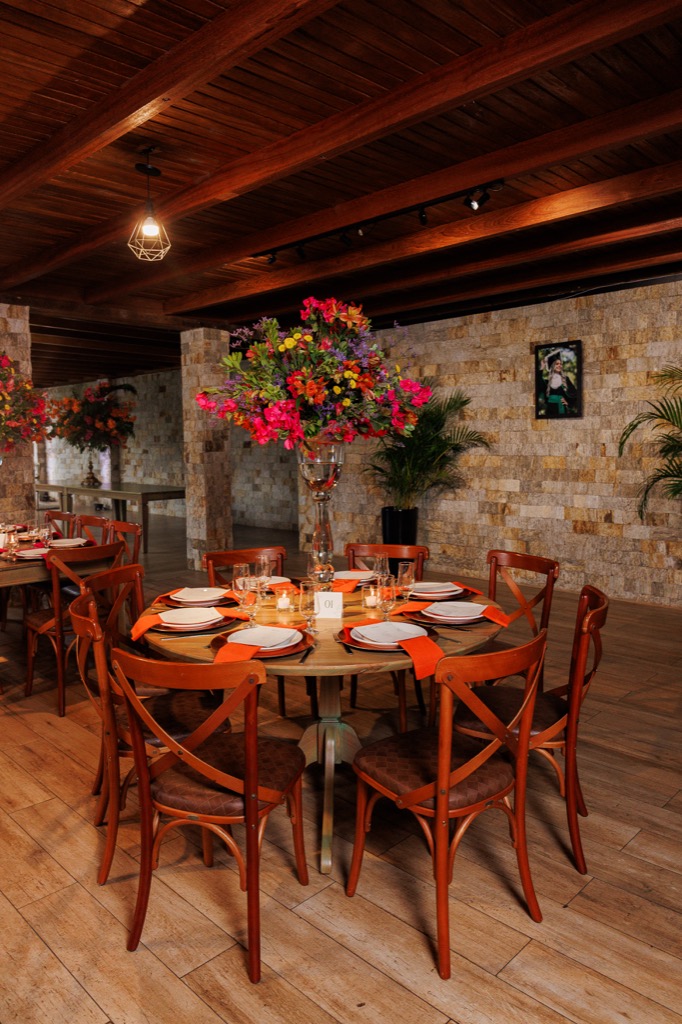 Salão de eventos na Chácara do Cris — mesas com arranjos florais e pilares de pedra